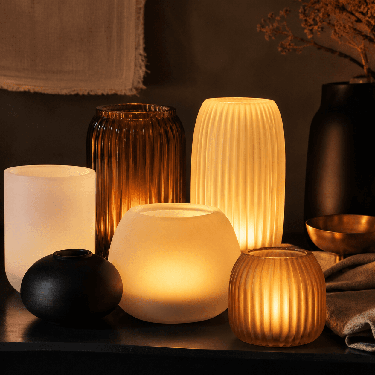 A cluster of flameless LED-style decorative light objects that give a soft amber glow with no open flame.
